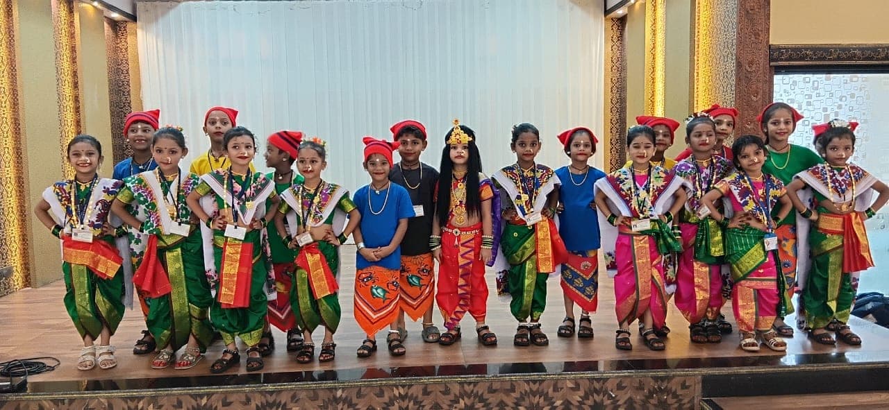 Kindergarten children on stage in traditional Maharashtrian dress, lined up after their performance.