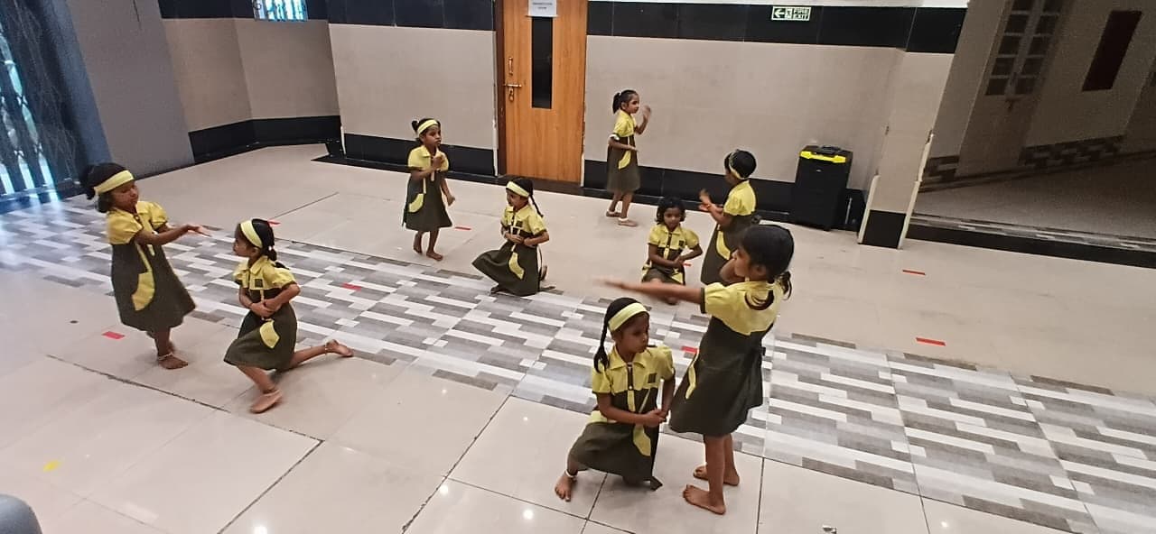 Kindergarten children dancing at a school performance.