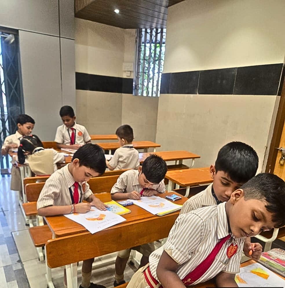 Students at wooden desks in a classroom, each colouring a drawing with crayons.