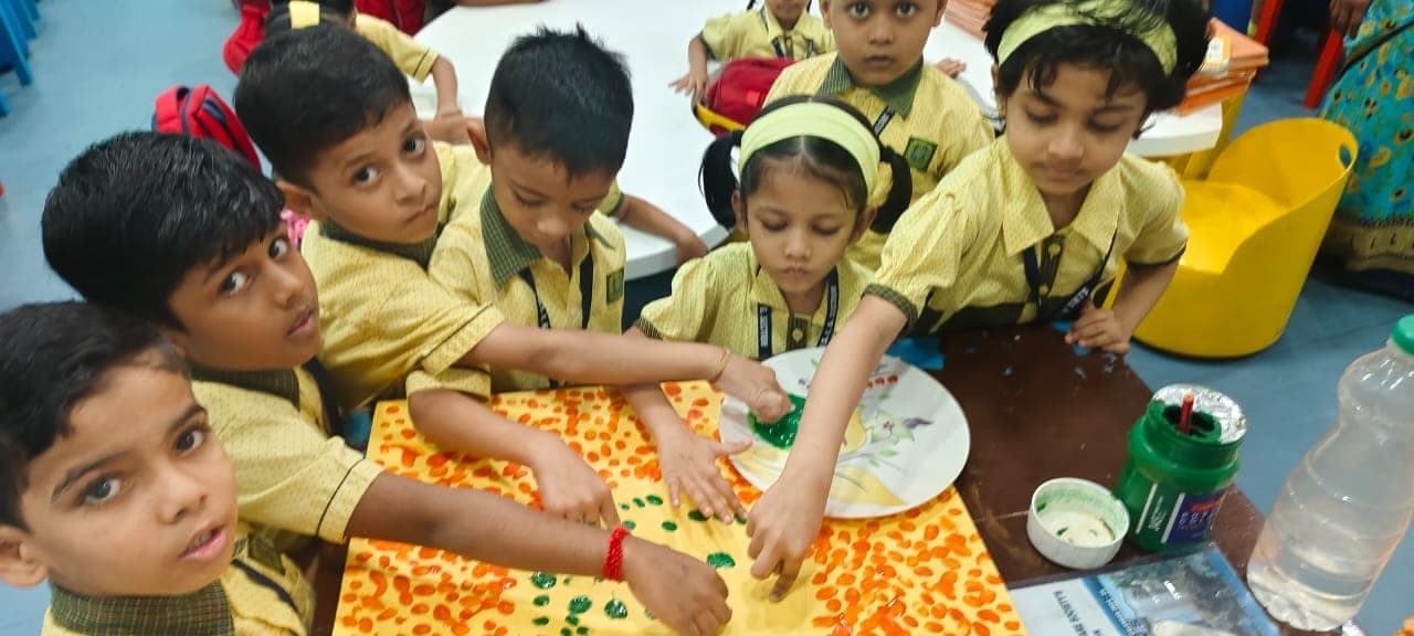 A Kindergarten child making a thumb painting.